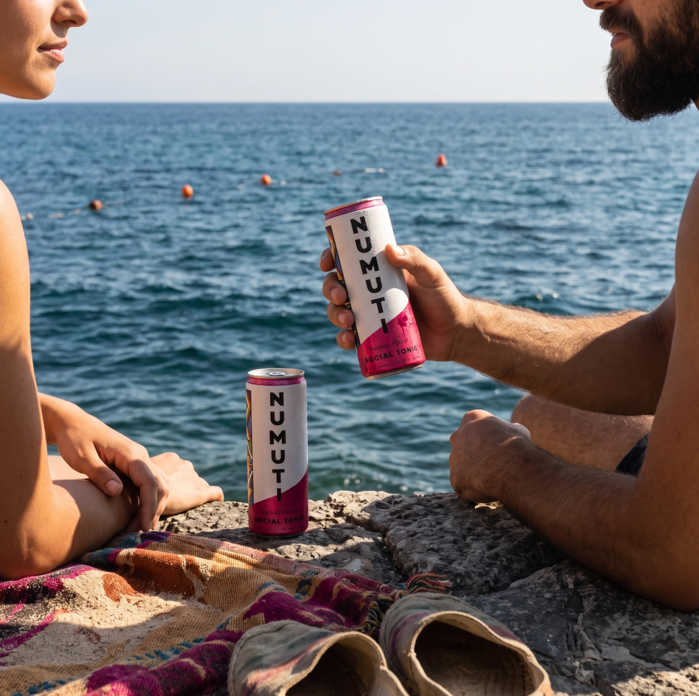Two people sharing NuMuti beside the sea